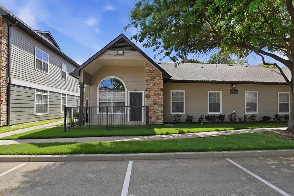 Building exterior and parking at Almeda Park Apartments in Houston TX